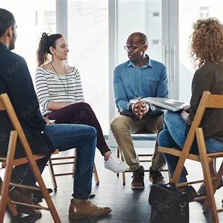 Support group in a circle, with emotional connection and shared vulnerability, representing culturally responsive therapy and emotional safety.