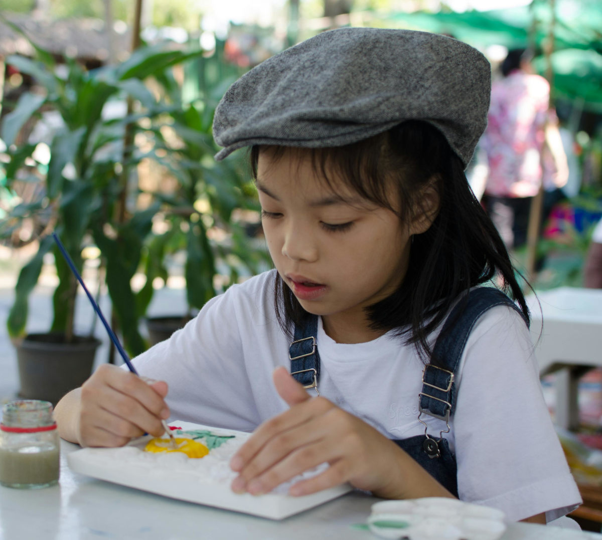 Kid is very concentrated on their painting